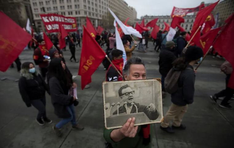 https://www.workersunity.com/wp-content/uploads/2023/09/demonstrator-shows-a-picture-of-former-Chilean-President-Salvador-Allende-chile.jpg